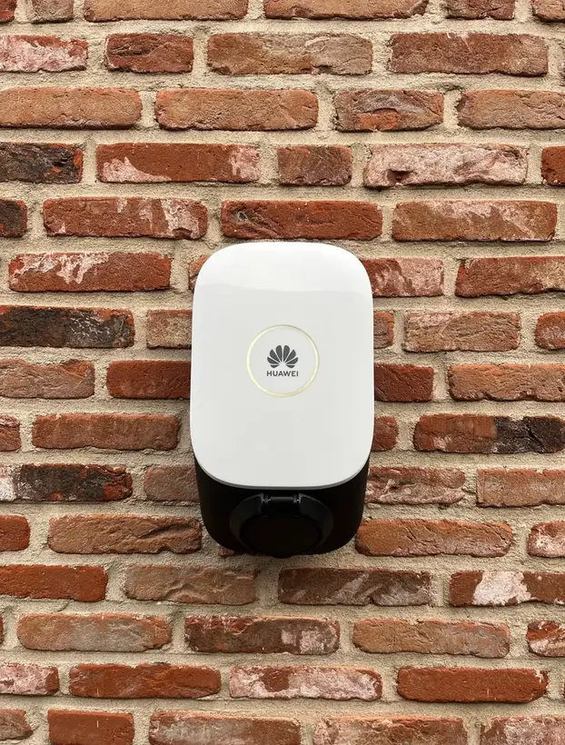 Borne de recharge Huawei installée sur une façade en brique